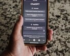 一只手拿着智能手机,屏幕上显示着ChatGPT界面
