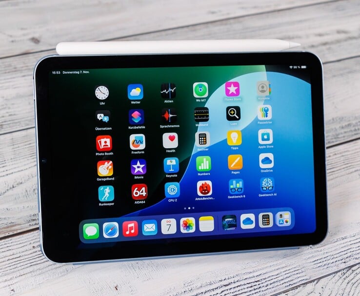 iPad mini 的正面图，上面放置Apple Pencil，显示放置在木质表面上的主屏幕。(图片来源：Notebookcheck）