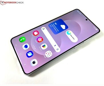 三星Galaxy S25 Edge 特写，显示屏扁平、边框纤薄，主屏幕上的天气和应用程序图标清晰可见。(图片来源：Notebookcheck）