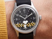 Timex MK1黑色表盘的特写镜头，表盘上以黄黑格纹为背景印有史努比图案，配有阿拉伯数字时标和夜光指针。