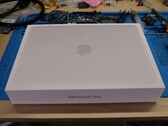 MacBook Neo 零售包装盒拆卸前放置在工作台上，以便升级固态硬盘