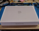 MacBook Neo 零售包装盒拆卸前放置在工作台上，以便升级固态硬盘