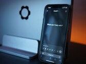 智能手机上显示着ChatGPT界面，其中显示了问题“有什么可以帮到您的吗？”
