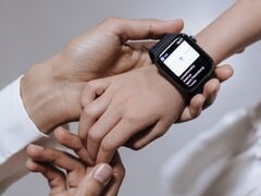 一位成年人正将智能手表戴在孩子的手腕上
