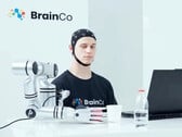 一名使用BrainCo公司脑控技术的用户，仅凭意念便机械般地抓起了一个苹果。