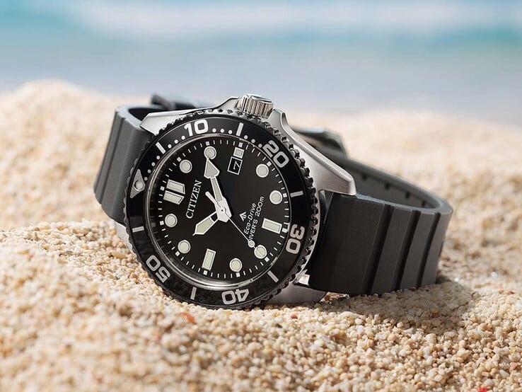 Citizen Promaster Marine BN0266-07E 腕表,配有黑色表盘、黑色表圈和黑色表带,静卧在沙地上。