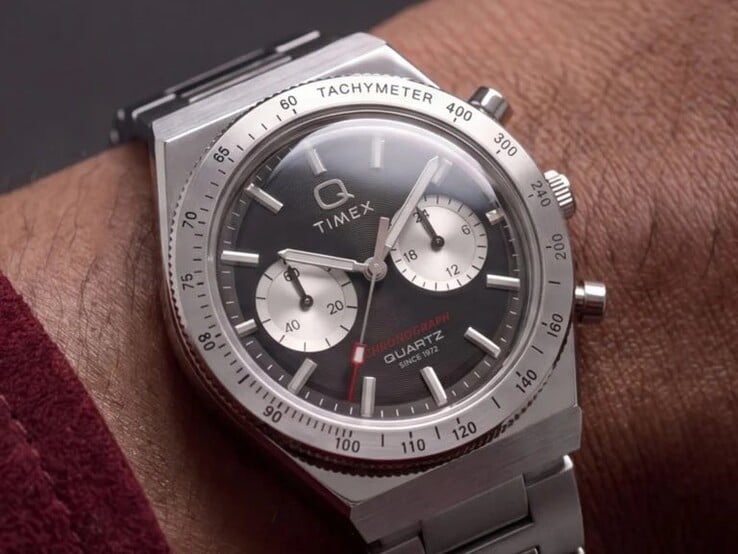 Timex Q Timex Continental 计时码表 TW2Y93200 佩戴在手腕上,采用黑色放射状CD风格表盘,配有两个银色小表盘、测速计表圈、夜光刻度以及一体式不锈钢表链。