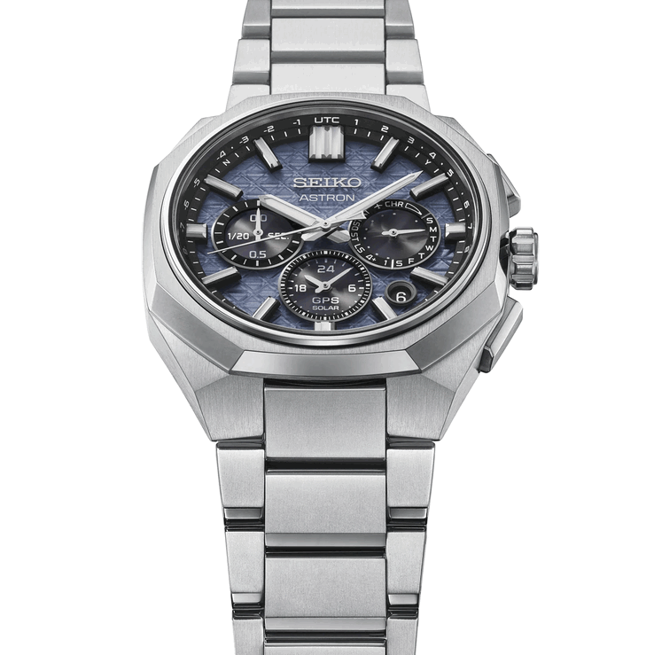 精工 Astron HAB001 正面斜视图,显示其琢面钛金属表圈、一体化表链和蓝色纹理表盘。