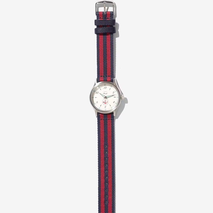 Noah x Timex MK1 Anchor 腕表，配有银色调 36 毫米表壳、奶油色表盘、锚形图案以及海军蓝和红色条纹织物表带。