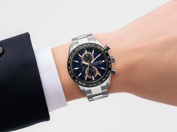 佩戴在手腕上的 Citizen Attesa AT8297-51L 计时腕表，展现其海军蓝表盘、玫瑰金色点缀和黑色世界时表圈。