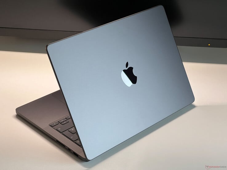 Apple 太空灰 MacBook Pro 放在桌子上，盖子部分打开，显示键盘和Apple 徽标（图片来源：Notebookcheck）。