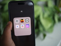 手握一部智能手机,屏幕上显示一个装满 AI 应用的文件夹