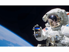 免费 NASA+ 服务的宣传图片，图片中一名宇航员手持智能手机，在太空中打开 NASA+ 应用程序。(图片来源：美国国家航空航天局）