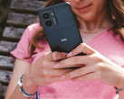 HMD Fusion 智能手机的宣传图片，展示了一位女士手中的手机以及背面的 HMD 徽标特写。(图片来源：HMD）