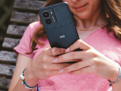 HMD Fusion 智能手机的宣传图片，展示了一位女士手中的手机以及背面的 HMD 徽标特写。(图片来源：HMD）