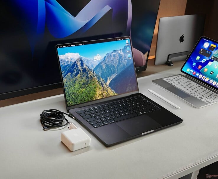 Apple 桌面上的 MacBook Pro，配有充电器和外接显示器（图片来源：Notebookcheck）