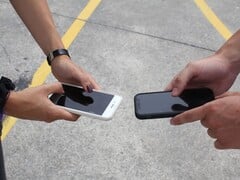 两个人在交接时并排拿着两部智能手机