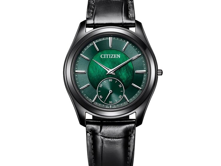 Citizen Eco-Drive One AQ5025-04N 的斜角特写,展现其闪耀的绿色珍珠母贝表盘、银色指针和刻度、黑色表壳及皮革表带。