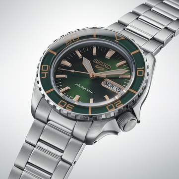 Seiko 5 Sports SKX HDB005 的特写,突显其深绿色表盘、玫瑰金色指针和立体时标,以及带有金色刻度的同色系绿色表圈。
