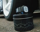 卡西欧 G-Shock DW5600TT25-1 x Toyo Tires 手表展示在以轮胎为主题的金属罐上，旁边还有一个汽车轮毂。