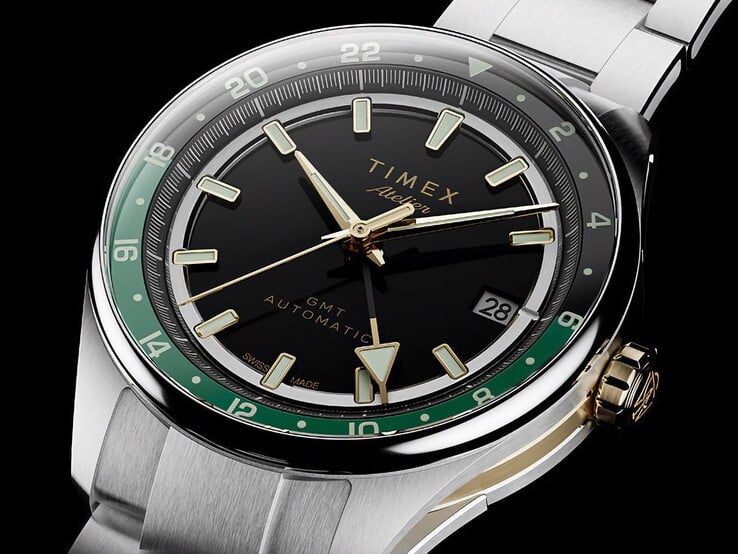 Timex Atelier GMT Première M1a 的斜视图,展示其黑色表盘、绿色 GMT 圈、金色表冠和不锈钢表链。