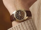 Timex Q 1978 Day and Date，配有棕色烟熏渐变表盘和金色表壳，搭配棕色皮革表带，佩戴于腕间。