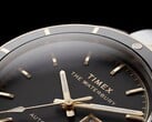 Timex Waterbury Heritage 自动腕表黑色表盘的特写，展示了其多面夜光指针、时标、星期日期显示以及黑色表圈。