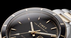 Timex Waterbury Heritage 自动腕表黑色表盘的特写,展示了其多面夜光指针、时标、星期日期显示以及黑色表圈。