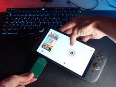 来自 YouTube 频道 Better Gaming 的 Yu 一手拿着任天堂 Switch 2，一手拿着开源绿色 PCB 适配器，试图将其插入设备的 microSD Express 插槽（图片来源：Better Gaming via YouTube）