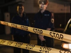 两名警察夜间站在写着“Stop”的黄色警戒线后面