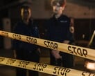 两名警察夜间站在写着“Stop”的黄色警戒线后面