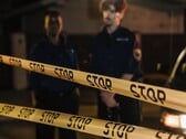 两名警察夜间站在写着“Stop”的黄色警戒线后面