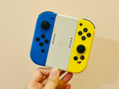 图片。一只手拿着 Joy-Cons （图片来源：Gwen King on Unsplash）