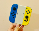 图片。一只手拿着 Joy-Cons （图片来源：Gwen King on Unsplash）