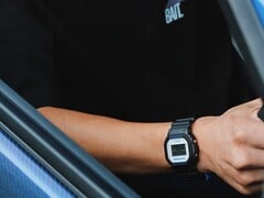 一名佩戴卡西欧G-Shock DW5600TT25-1 x Toyo Tires手表的人正坐在车内。
