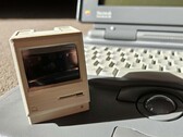 Pico Mac Nano 只有 6 厘米高，与背景中的 Powerbook 180 对比即可看出。