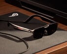 ROG Xreal R1 配有底座,售价 849 美元。如图所示:宣传图片,显示眼镜放在桌子上。