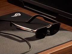 ROG Xreal R1 配有底座，售价 849 美元。如图所示：宣传图片，显示眼镜放在桌子上。