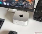 一台搭载 Apple M6 处理器的 Mac mini 置于游戏设置的桌面上，配有显示器、键盘、鼠标和扬声器。