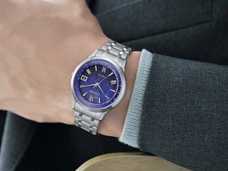 佩戴在手腕上的 Citizen Exceed CB1140-79L,以深色夹克为背景,展示其蓝色表盘、银色表壳和一体式钛金属表链。