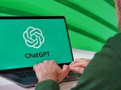 一名男子正在笔记本电脑上打字,屏幕上可见ChatGPT的标志