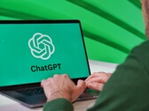 一名男子正在笔记本电脑上打字，屏幕上可见ChatGPT的标志