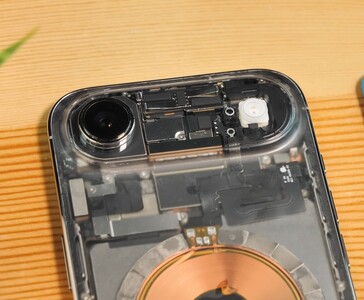 透明 iPhone Air 的特写，显示透明背板下暴露的相机模块、闪光灯和内部组件。(图片来源：Phone Repair Guru via YouTube）