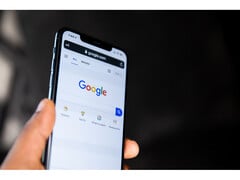 一张手持智能手机的照片，屏幕上打开的是谷歌搜索主页。(图片来源：Solen Feyissa on Flickr）