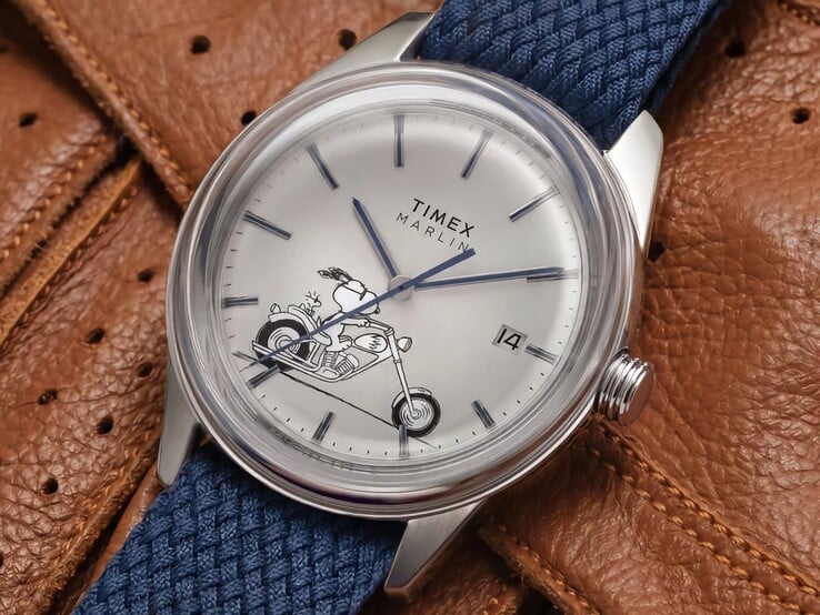 《花生漫画》× Timex Marlin Jet Automatic Easy Rider 腕表的斜角正面视图,突出了其拱形表镜、银色调不锈钢表壳、史努比主题表盘以及蓝色织物表带。