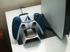 以《战神》为主题的定制 DualSense 控制器放在 PlayStation 5 游戏机前的充电底座上。(图片来源：FOX ^.ᆽ.^= ∫)