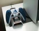 以《战神》为主题的定制 DualSense 控制器放在 PlayStation 5 游戏机前的充电底座上。(图片来源：FOX ^.ᆽ.^= ∫)