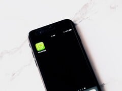 放在白色桌子上的智能手机,屏幕上显示着 WhatsApp 应用