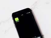 放在白色桌子上的智能手机，屏幕上显示着 WhatsApp 应用