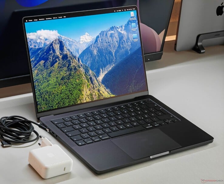 Apple 桌面上配备 M5 芯片的 MacBook Pro 及其充电器和数据线。(图片来源:Notebookcheck)